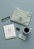 Branded office items featuring M.H.E Home Health Care logo on a shirt, notebook, and business card.