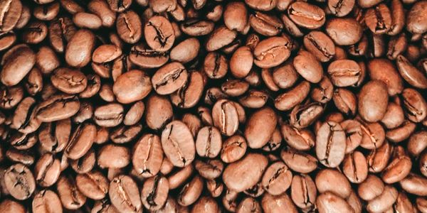 Close-up of roasted coffee beans in various shades of brown.