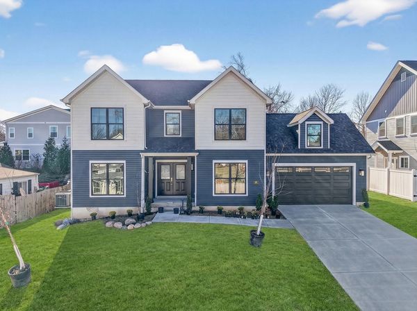 Modern two-story house with blue and white exterior and a well-kept lawn.