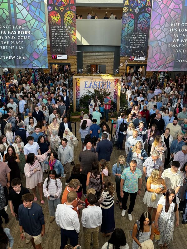 Large crowd gathered for an Easter celebration inside a church lobby.