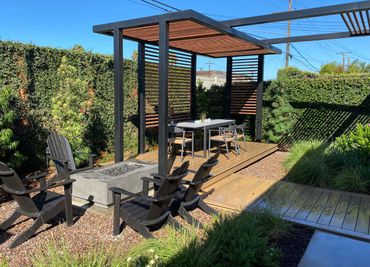 custom pergola shade structure over floating deck dining area with fire feature