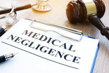clipiboard that reads medical negligence , stethescope and gavel