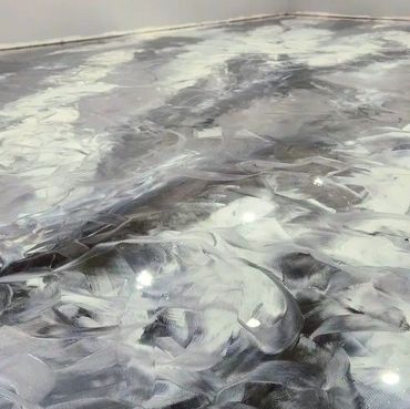 Empty room with a shiny, reflective epoxy floor and grey walls.