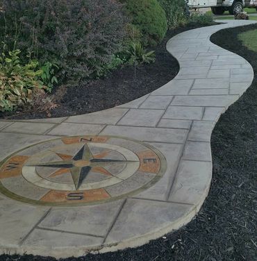 Curved concrete walkway with a compass design embedded near the start.
