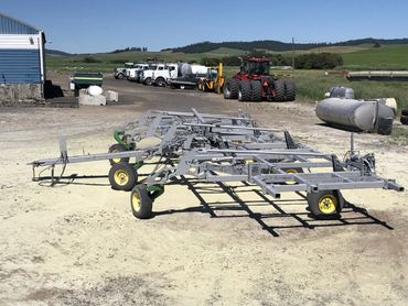 Farming equipment with tractors and trucks in a rural area.