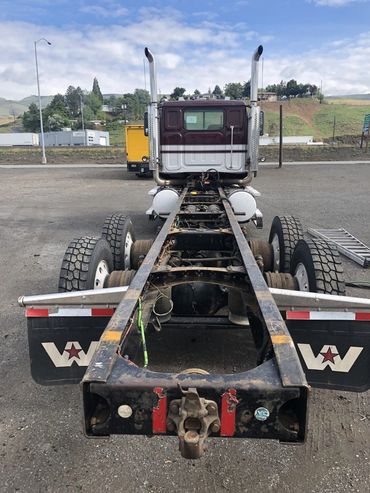 Rear view of a stripped-down semi truck chassis without a trailer attached.