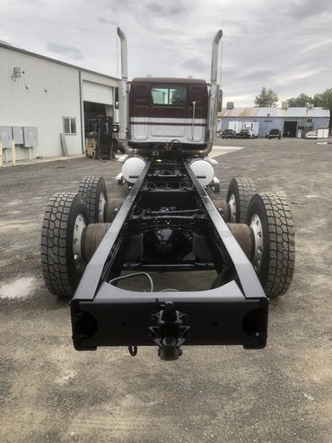 Rear view of a heavy-duty truck chassis without a cargo bed.