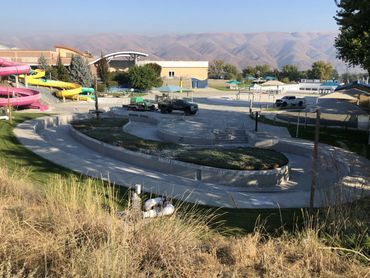 Outdoor water park with slides and empty pools under a clear sky.