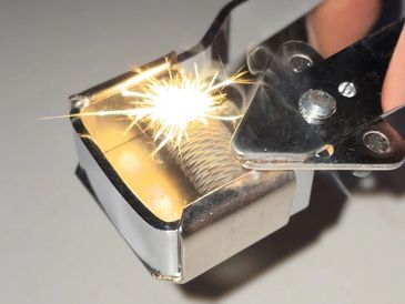 Close-up of a metal lighter producing sparks.