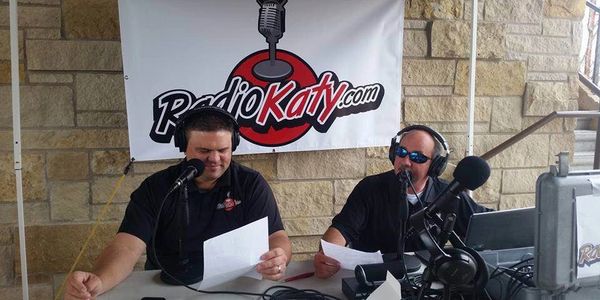 Two radio hosts broadcasting live from a Cane Island event with RadioKaty.com.