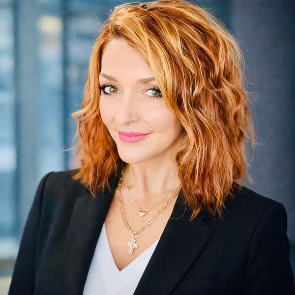 Professional woman with red hair and a confident smile in a black blazer, Family Nurse Practitioner Tara Blanchard