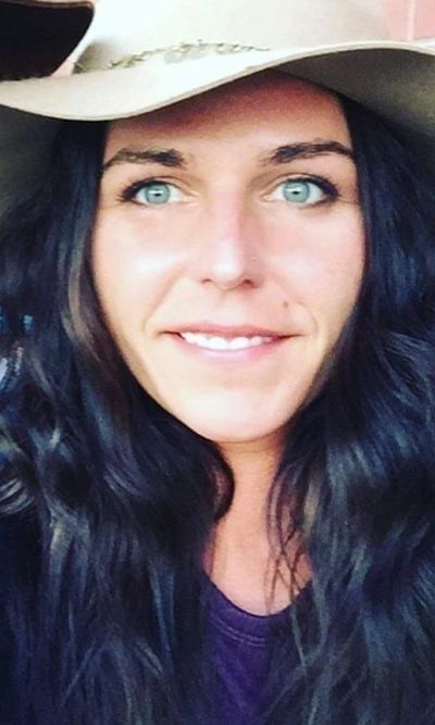 girl smiling with dark brown hair, green eyes and a hat on