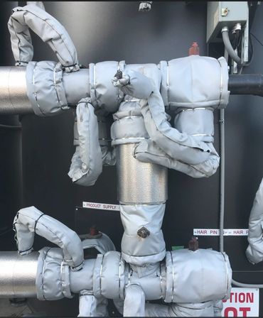 Industrial pipes wrapped in protective insulation material.