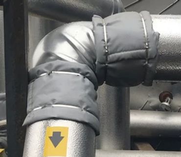 Insulated industrial pipe with a directional arrow label.