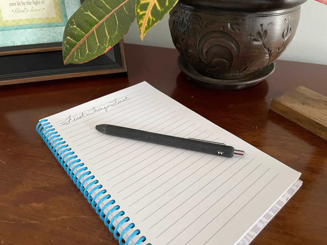 Desk with notebook that has the words First Things First. 