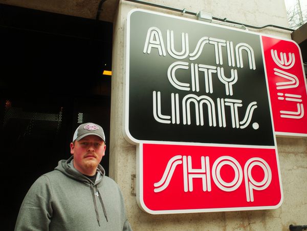Man standing in front of Austin City Limits Live Shop sign.