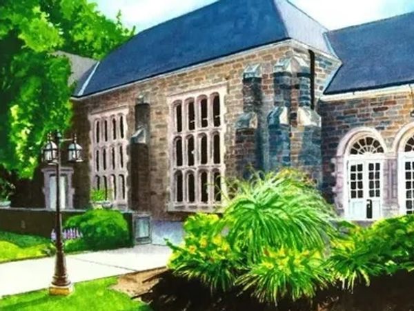 A picturesque stone building surrounded by lush greenery and a vintage street lamp.