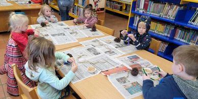 a photo of a group of our Story Time kids doing arts and crafts.