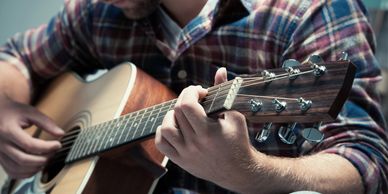 Stock photo image of a man playing an acoustic guitar.