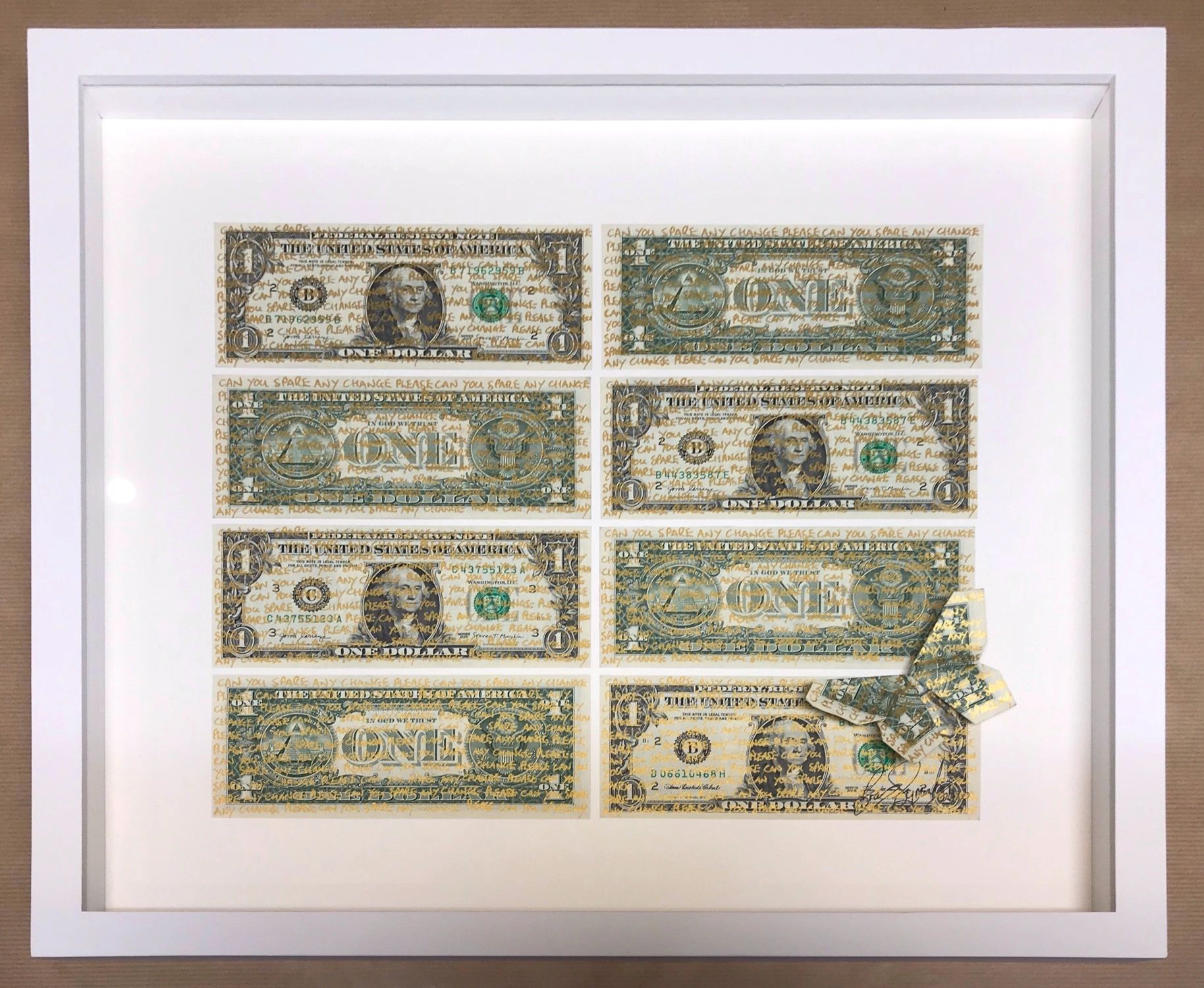 Eight dollar bills framed in a white frame with an origami butterfly sitting on one of them.