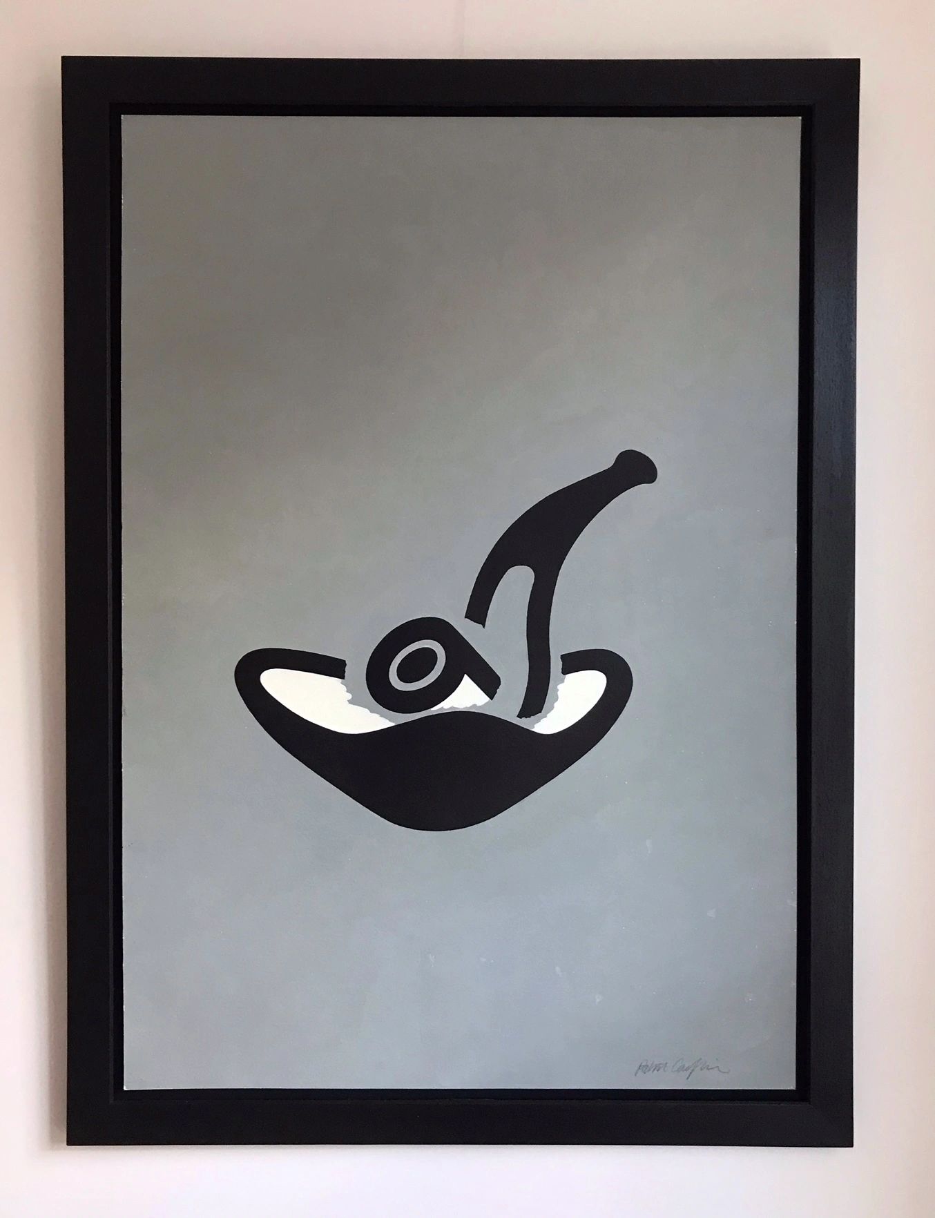 A picture of a black pipe sitting in a black and white ashtray, on a large grey background.