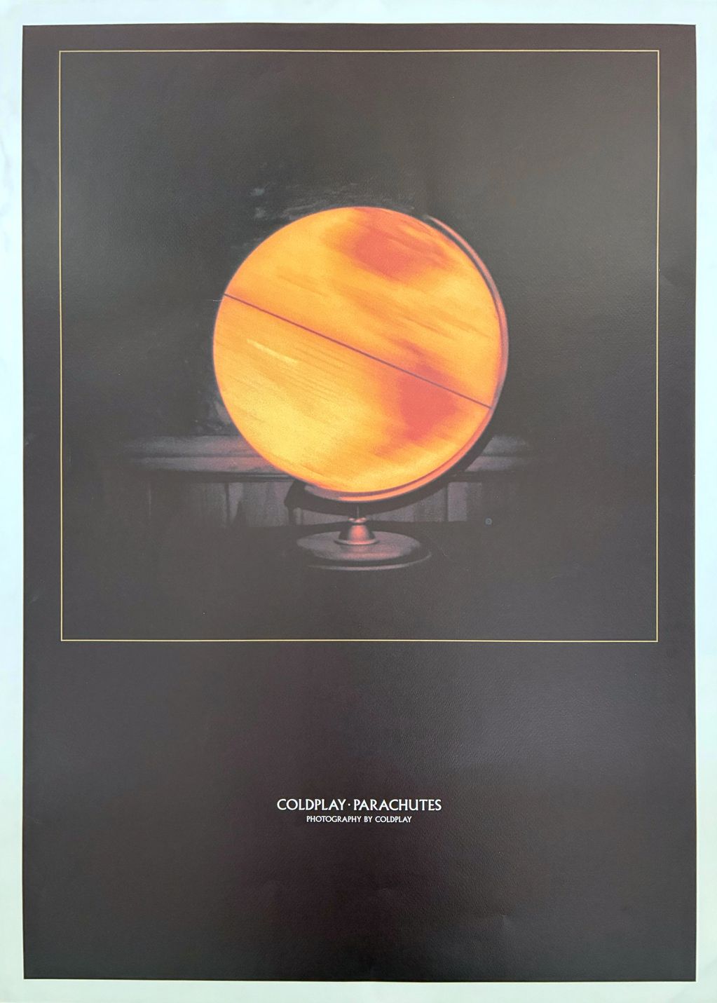 Image of Coldplays "Parachutes" album cover. This is an image of an orange planet on a table top glo