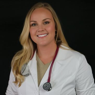 Smiling female doctor wearing a white coat and stethoscope.
