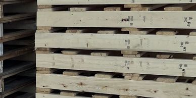 Stack of wooden pallets arranged in a warehouse.