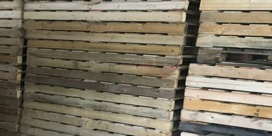 Stacks of wooden pallets arranged in a warehouse.