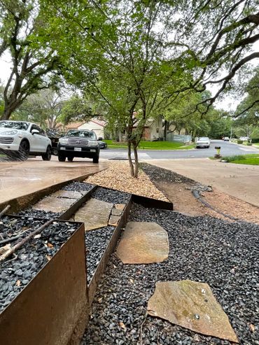 Corten steel raised flower beds and stairs with flagstone as stepping stones