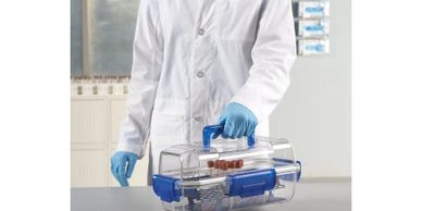 Scientist holding a portable lab container with samples.