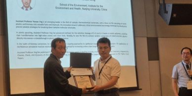Award presentation at a seminar with a projector screen.