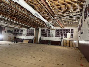 A gymnasium with its floor removed and ceiling partially dismantled.
