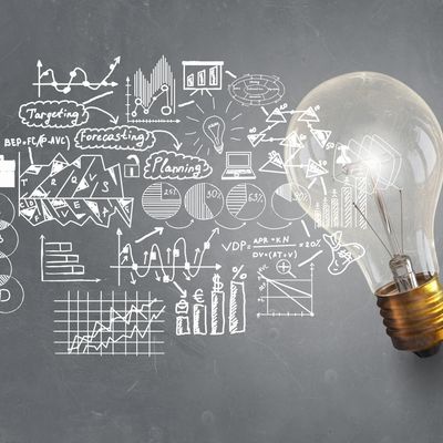 Light bulb with charts & strategy diagrams symbolizing innovation, planning, & data-driven strategy.