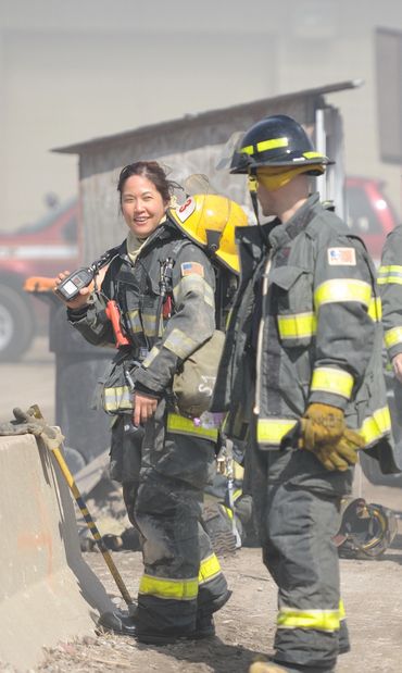 Asian female firefighter with the nozzle,