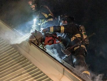 Firefighter cutting  a roof with a target saw.