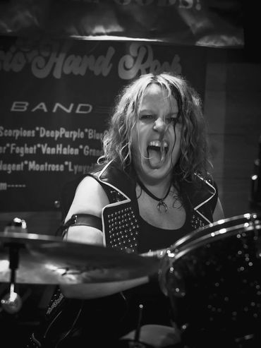 Energetic drummer passionately playing with intensity on stage.