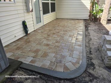 Newly paved patio with a clean border near a house.