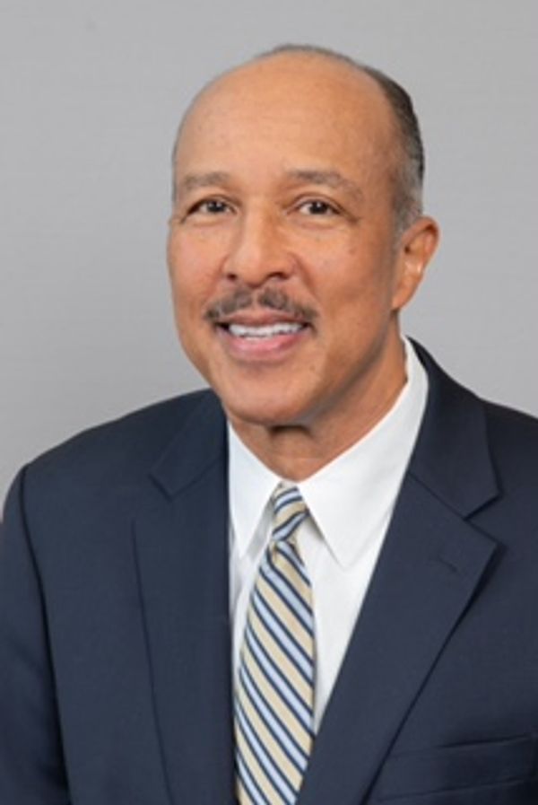 Portrait of a man in a business suit smiling.
