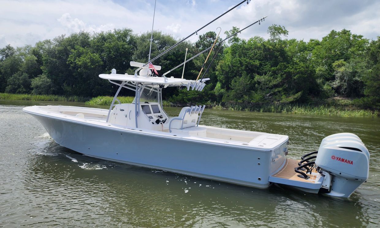 White fishing boat with Yamaha motor on calm water.