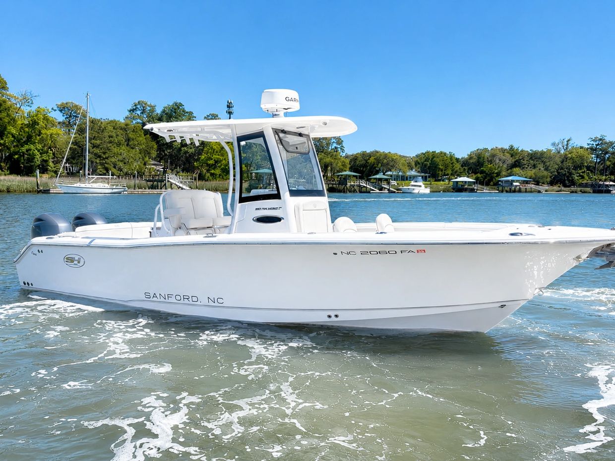 White motorboat cruising near the shore on a sunny day.