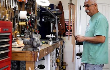 Robert Champion standing at his workbench in the workshop
