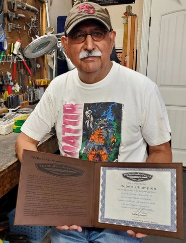 Robert Champion holding his Knifemakers Guild certificate