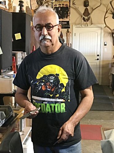 Robert Champion standing in his workshop holding a custom knife