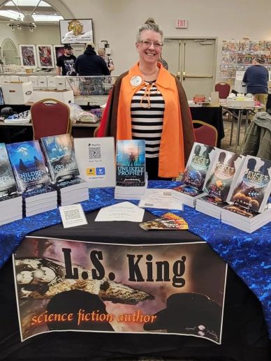 Author L.S. King at a book fair showcasing science fiction novels.