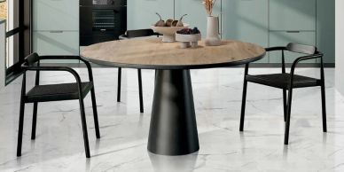 Modern round table with two black chairs.