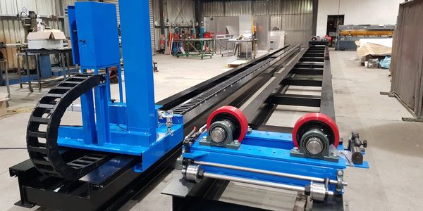 Industrial blue and black machinery with red wheels in a workshop.