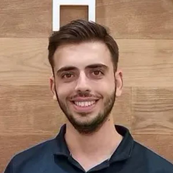 Smiling man with neatly styled hair and beard.