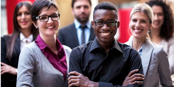 Group of people standing and smiling.