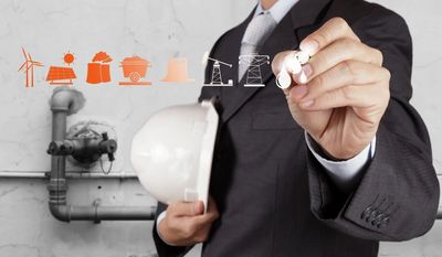 This is the image of a person in a suit holding a hardhat and drawing blueprints.,